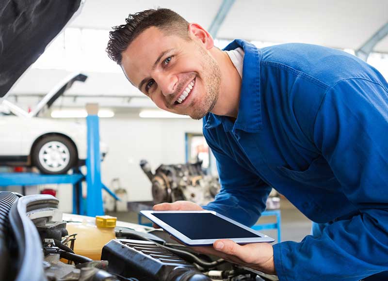 technician holding Ipad under car hood